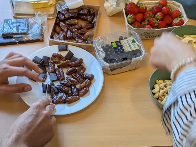 Verschiedene Lebensmittel wie Datteln, Heidel- und Erdbeeren, Schokolade, Nüsse und getrocknetes Obst werden zur Geschmachsprobe angerichtet.